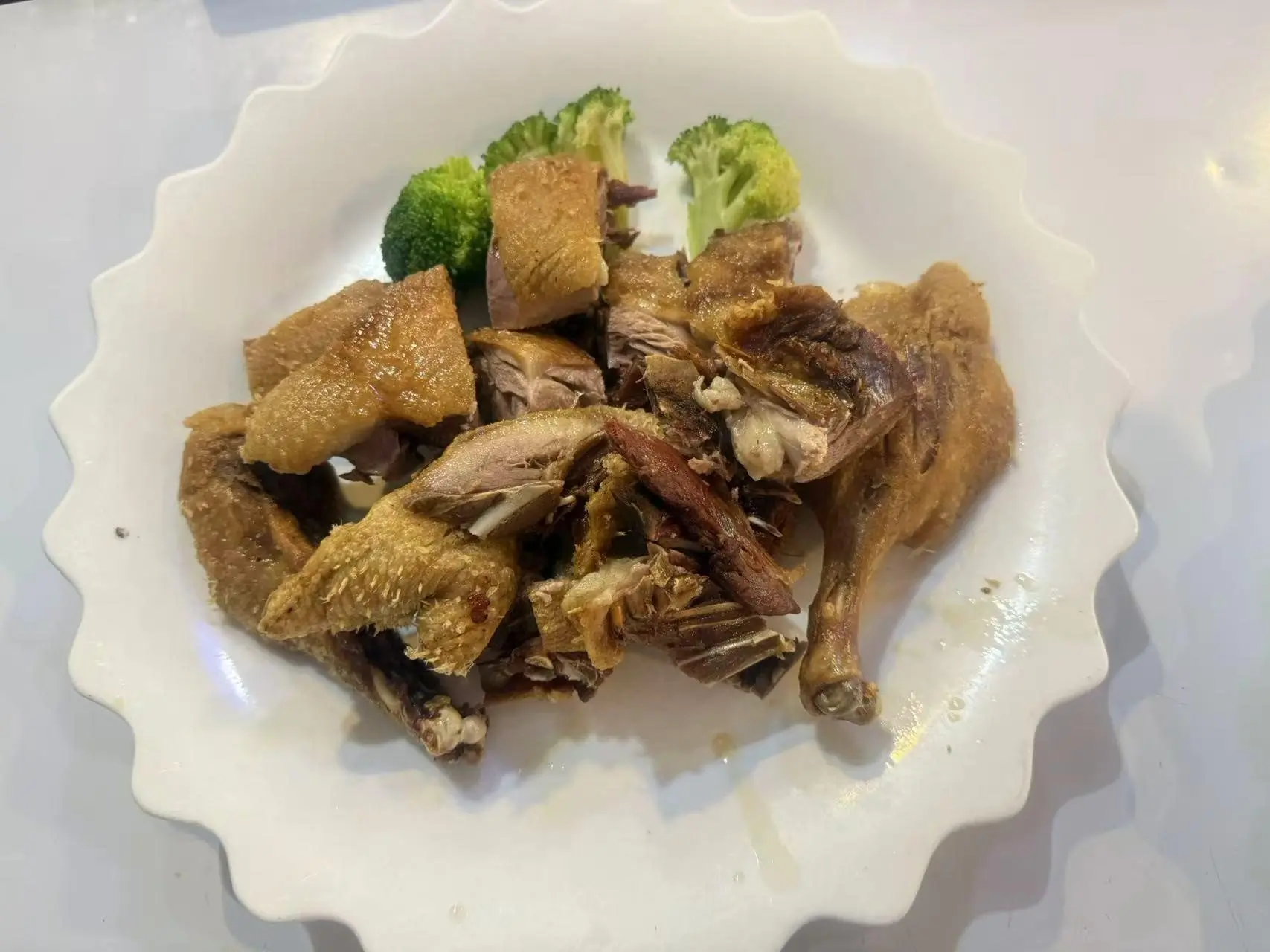 Crispy-Duck features pieces of crispy-skinned duck meat, accompanied by a few broccoli florets at China Panda, a Asian restaurant in Athens
